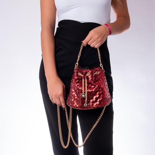 Metallic burgundy eco leather bucket bag, detachable chain and enamel evil eye. Dimensions 23x17cm.